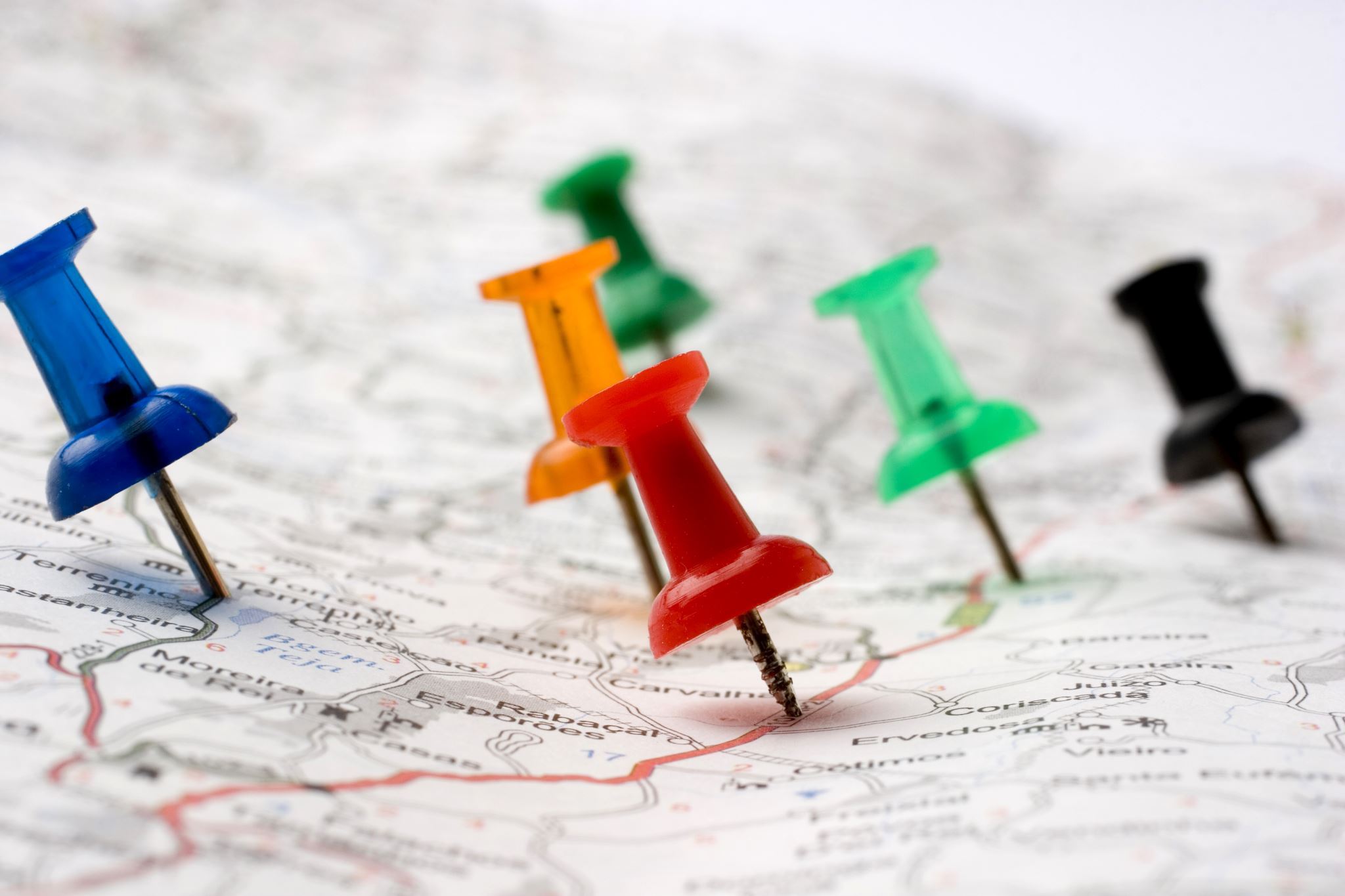 Six-pins-pointed-on-several-spots-on-a-road-map